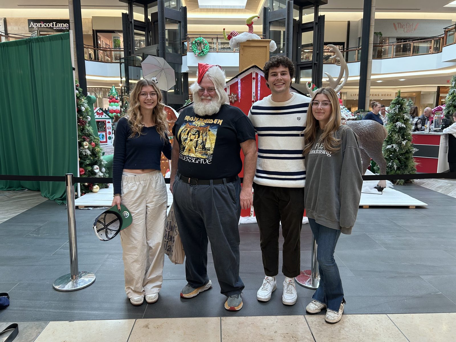 Friends posing with Santa at a mall